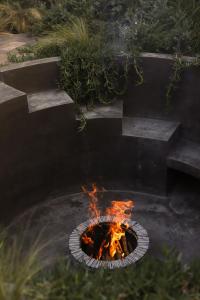 - un foyer extérieur dans un jardin orné de flammes dans l'établissement Quinta Amores alojamiento, à San Miguel de Allende