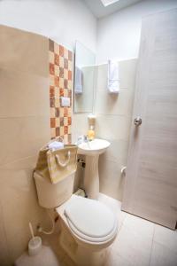 a bathroom with a toilet and a sink and a shower at KOMODO ALOJAMIENTO- hostal autoservicio - ubicado muy cerca al centro histórico -Habitaciones con baño privado, wifi , cama 2x2 in Popayan