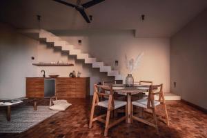 a dining room with a table and a staircase at Quinta Amores alojamiento in San Miguel de Allende