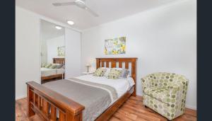 a bedroom with a bed and a chair at Entire 2 bedroom townhouse - Four Mile Beach Escapes - your home away from home in Port Douglas +27 photos