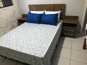 łóżko z niebieskimi poduszkami w pokoju w obiekcie Casa com piscina em Balneário Camboriú w mieście Balneário Camboriú