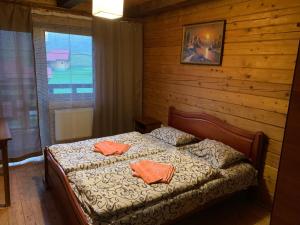 een slaapkamer met een bed met 2 oranje kussens erop bij Baza vidpochynku Ilz in Slavske