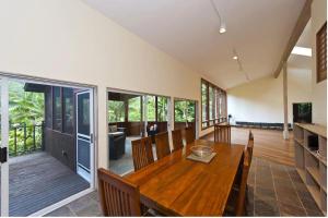 a dining room with a wooden table and chairs at Waipio Valley Botanical Garden 