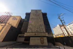 a tall building with a christmas tree on it at Hotel Lium in Cheonan