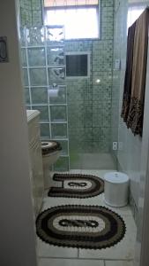 a bathroom with a toilet and a shower with a mosaic floor at Cafofo da Rosane in Pelotas +23 photos