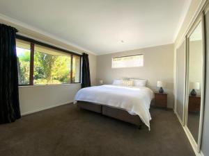 a bedroom with a bed and a large window at 12 Tarndale Place in Hanmer Springs