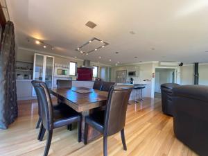 a dining room and living room with a wooden table and chairs at 12 Tarndale Place in Hanmer Springs