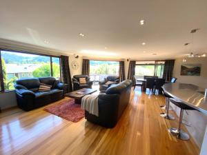 a living room with a couch and a table and chairs at 12 Tarndale Place in Hanmer Springs