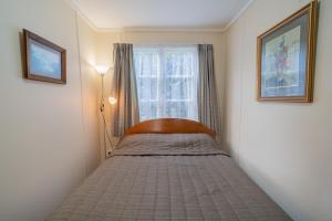 Un pat sau paturi într-o cameră la Rustlein Cottage - Te Anau Holiday Home