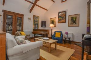 a living room with a couch and a piano at Townend Barn in Lydford