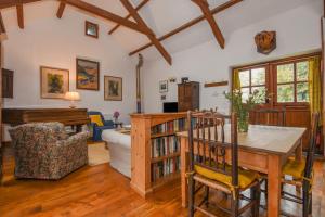 a living room with a wooden table and a piano at Townend Barn in Lydford