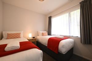 a hotel room with two beds and a window at Riccarton Mall Motel in Christchurch