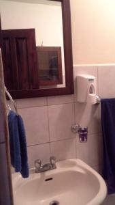 y baño con lavabo, espejo y toallas azules. en Room in Condo - Nice condo to vacation in Playas del Coco, en Coco