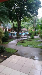 uma passagem que leva a uma piscina com uma árvore em Room in Condo - Nice condo to vacation in Playas del Coco em Coco