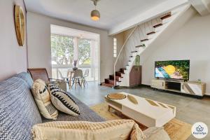 a living room with a couch and a tv at T3 - Duplex Moringue 2 étoiles - Vue sur Jardin - Proche centre Saint-Denis in Saint-Denis