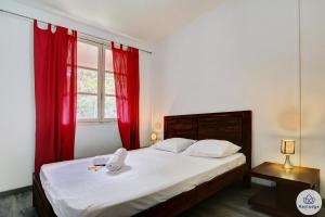 a bedroom with a large bed with red curtains at T3 - Duplex Moringue 2 étoiles - Vue sur Jardin - Proche centre Saint-Denis in Saint-Denis