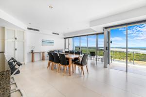 a dining room with a table and chairs at The Duporth Riverside in Maroochydore