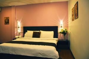 a bedroom with a large bed with pink walls at D'View Hotel in Kuala Perlis
