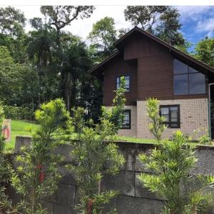 a house with trees in front of it at Casa de campo Rosa dos ventos in Rodeio