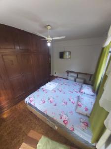 ein Schlafzimmer mit einem Bett mit rosa Blumen drauf in der Unterkunft Pousada e Hospedaria Regina in Cachoeiro de Itapemirim