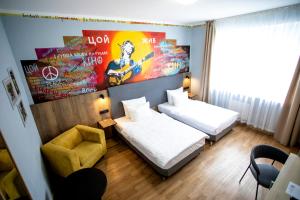 Pokój hotelowy z 2 łóżkami i krzesłem w obiekcie Ays Design Hotel Rosa Khutor w mieście Estosadok