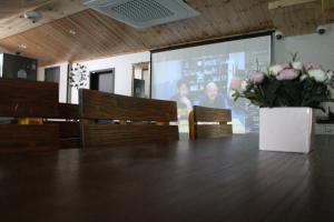 a conference room with a table and chairs and a screen at The Road Hotel in Seoul