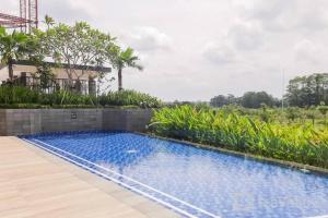a swimming pool in front of a house at Marigold Apartment Nava Park Central BSD in Tangerang