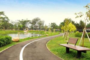 タンゲランにあるMarigold Apartment Nava Park Central BSDの曲がりくねった道の脇に座るベンチ +2枚の写真