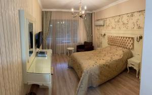 een slaapkamer met een bed, een bureau en een televisie bij Termal Elit Hotel in Gokcedere