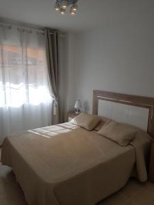 a bedroom with a large bed with a window at Sunshine in Costa Calma
