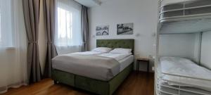 ein Schlafzimmer mit einem Bett und einem Etagenbett in der Unterkunft Exceptional Pogegen Apartment in Pagėgiai