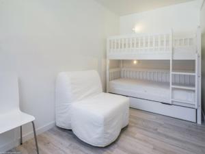 Plagne 1800にあるAppartement Plagne 1800, 3 pièces, 6 personnes - FR-1-351-20の白い二段ベッドとスツール付きの白いベッドルーム1室が備わります。