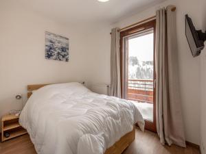 a bedroom with a white bed and a window at Appartement La Plagne, 3 pièces, 6 personnes - FR-1-351-93 in La Plagne
