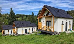 una fila de casas en un campo con árboles en Chatki wisla houses, en Wisła