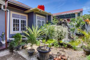 una casa azul con plantas delante en OYO 90526 New Bunga Sonsang Homestay Syariah, en Padang