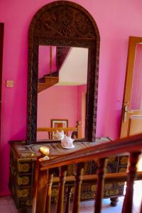a mirror on a table in a room with pink walls at Garden Lodge in Zanzibar City