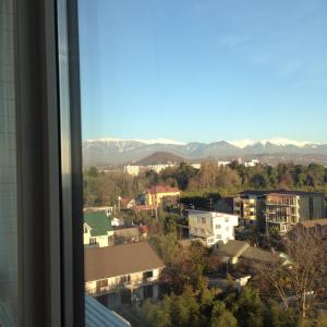 uma vista a partir de uma janela de uma cidade com montanhas em Sea Rapsody Apartment em Adler