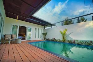 a house with a swimming pool on a wooden deck at Jungle Bay Resorts & Spa in Wayanad