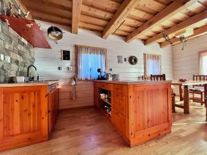a kitchen with wooden cabinets and a stone wall at Chata Musica in Nižné Malatíny