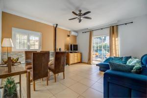 een woonkamer met een blauwe bank en een tafel bij Casa Coxy 3 Bed enclosed private in Chiclana de la Frontera