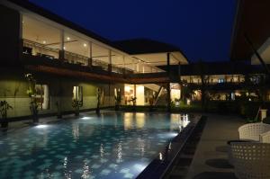 a swimming pool in front of a building at night at Bumi Gumati Resort & Convention in Bogor