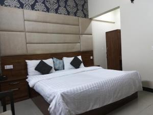 a bedroom with a large bed with white sheets and pillows at Karachi Guest House in Karachi
