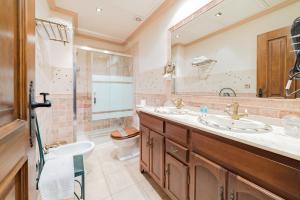 a bathroom with two sinks and a shower at Hotel Posada del Toro in Granada