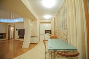 a dining room with a green table and chairs at Апартаменты Петровские 80 кв м 2 комнатная в центре in Tomsk