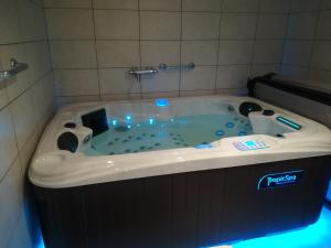 a jacuzzi tub in a bathroom with blue lights at appartement avec Jacuzzi hammam sauna privatisé au rez de chaussée ds maison à Voglans à 2 kilomètres du lac du bourget en Savoie entre Chambéry et Aix les Bains cure thermale in Voglans
