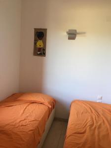 een slaapkamer met 2 bedden en een schilderij aan de muur bij Irini’s house in Chios