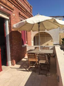 een tafel en stoelen onder een parasol op een patio bij Irini’s house in Chios