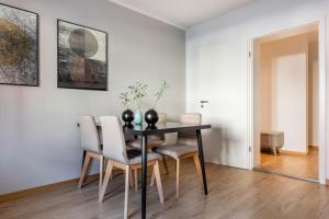 a dining room with a black table and chairs at Limehome Augsburg Pilgerhausstraße in Augsburg