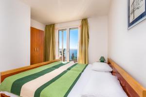 ein Schlafzimmer mit einem großen Bett mit Fenster in der Unterkunft Apartments Katica in Mlini