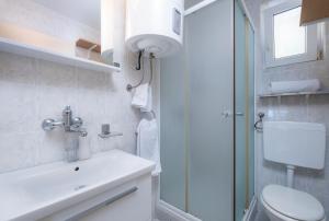 ein Badezimmer mit Toilette, Waschbecken und Dusche in der Unterkunft Apartments Katica in Mlini